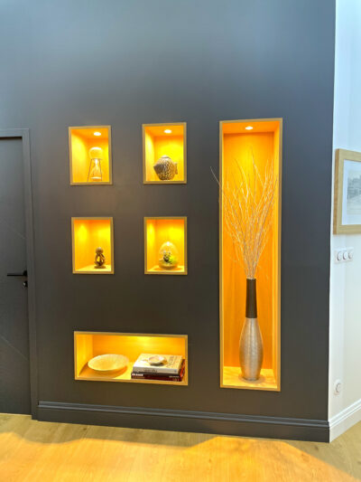 Niches murales en chêne avec éclairage intégré par spots LED.